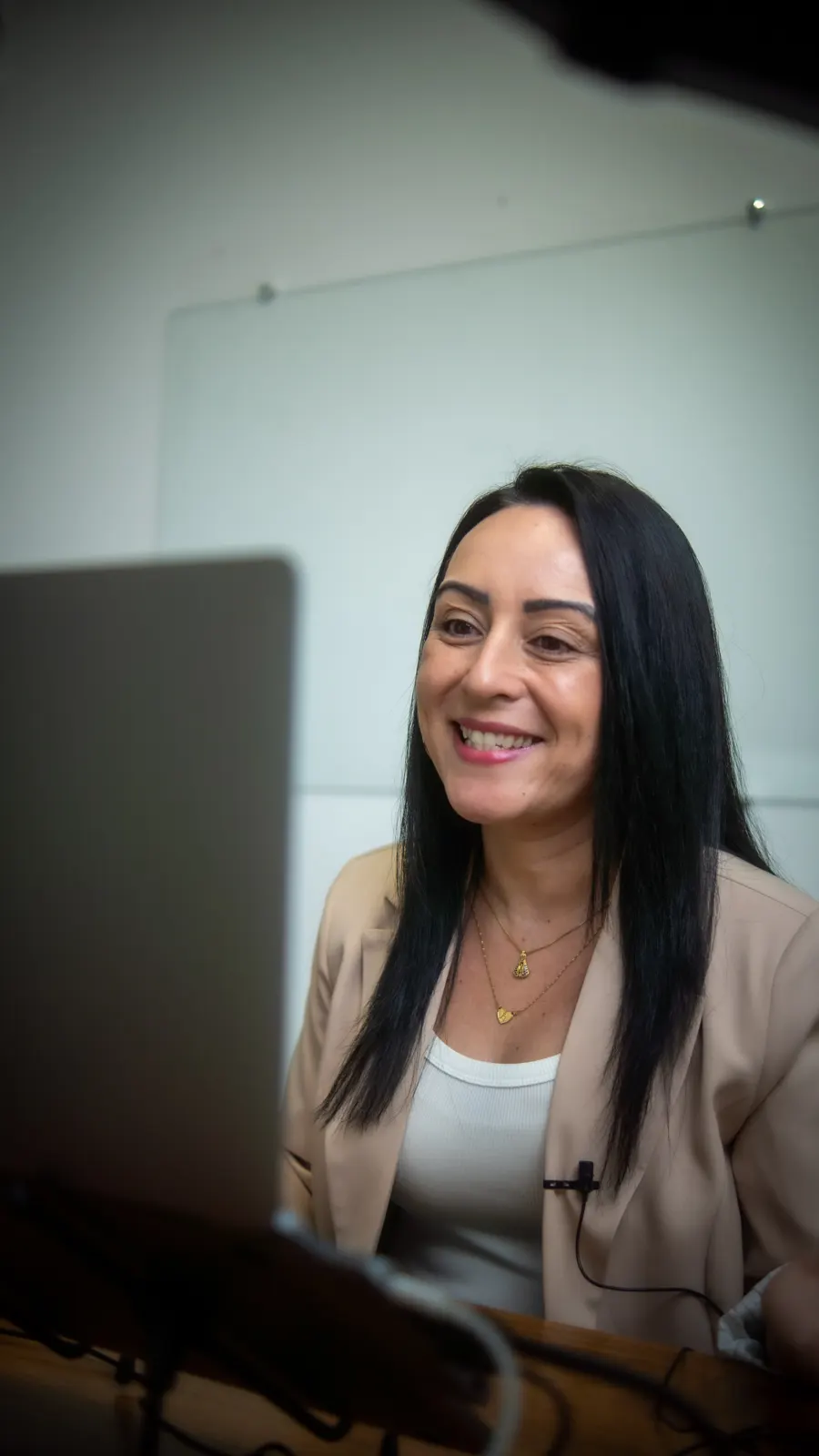 Professora da English Senior gravando uma aula diante do notebook